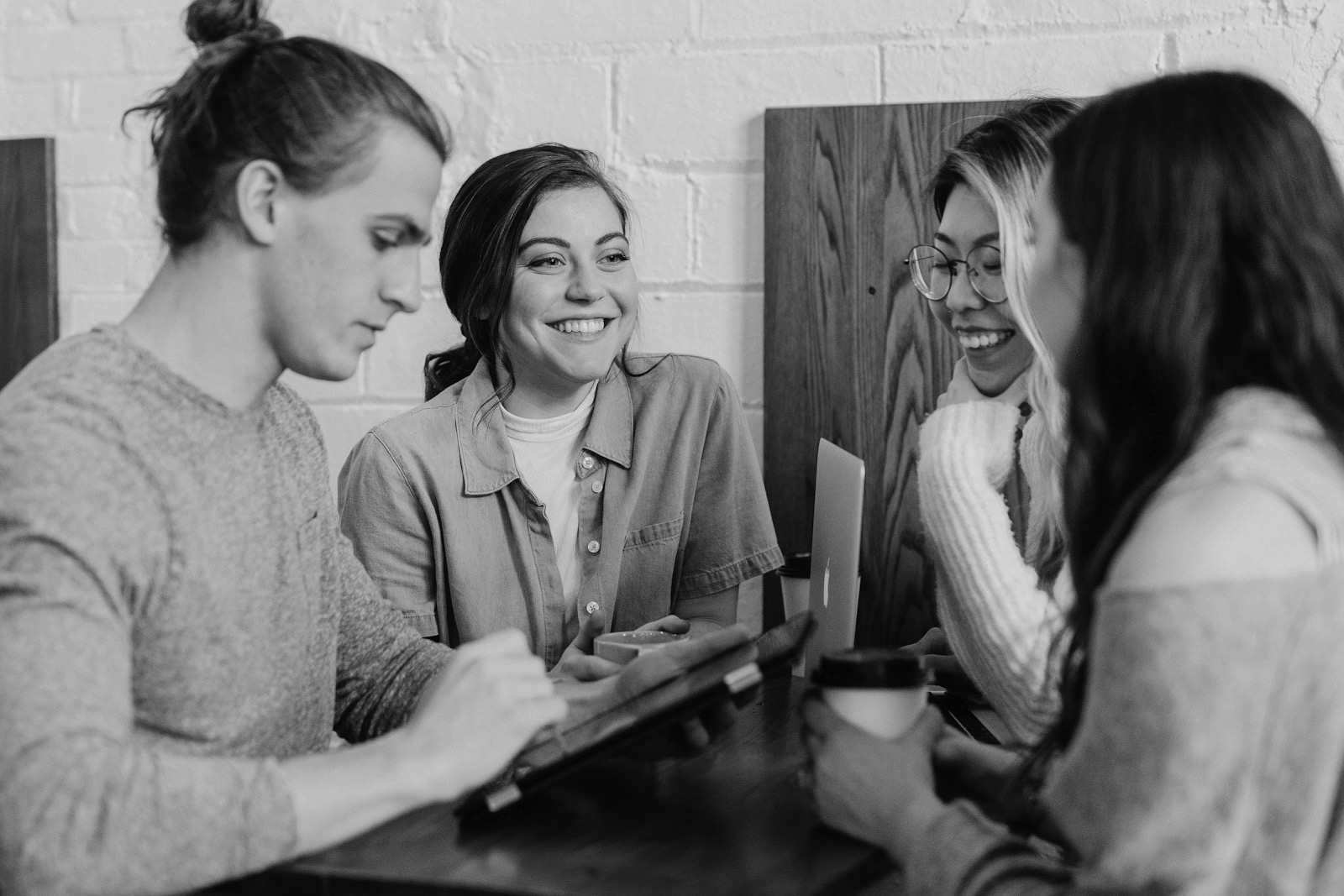 Cuatro personas charlando con un café — la conversación que intentamos hacer más fácil.